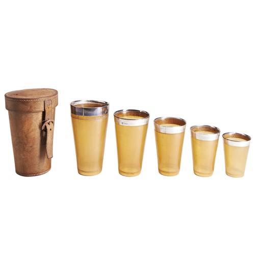 72 - A SET OF FIVE NESTING HORN BEAKERS IN A LEATHER CASE, each with a silver rim and hallmarked for Lond... 