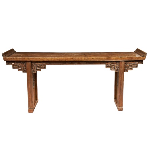 85 - A CHINESE CARVED ELM ALTAR TABLE, late Qing Dynasty, the shaped apron carved with stylized archaisti... 