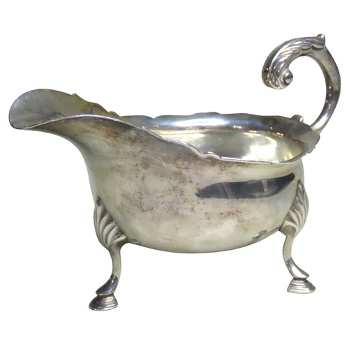 515 - A LATE VICTORIAN SILVER SAUCEBOATLONDON 1899with a 'S' scroll handle and undulating rim, raised on t... 