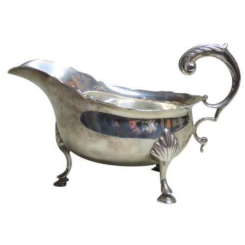 515 - A LATE VICTORIAN SILVER SAUCEBOATLONDON 1899with a 'S' scroll handle and undulating rim, raised on t... 