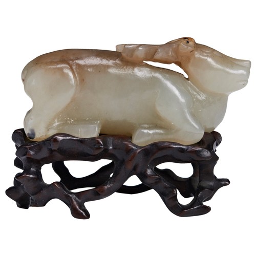 107 - A SMALL JADE CARVING OF A RECUMBENT BUDDHIST LION MING / QING DYNASTY, 17TH CENTURY青白玉狮 十七世纪with two... 