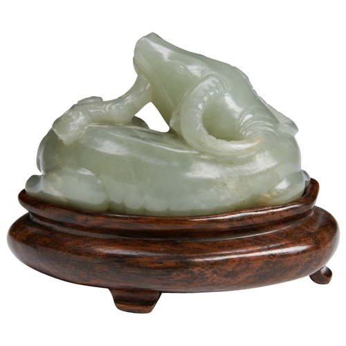 128 - A PALE CELADON JADE BUFFALOQING DYNASTY, 18TH CENTURY青白玉牛 清 十八世纪crisply carved with its head turned ... 