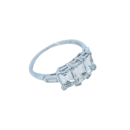 A PLATINUM AND DIAMOND THREE STONE RING BY OSCAR HEYMAN, 