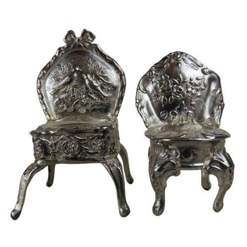 7 - A SILVER MINIATURE TABLE AND TWO MINIATURE CHAIRSthe repousse decorated table marked Birmingham, 190... 