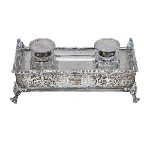 54 - AN EDWARDIAN SILVER INK STANDLONDON 1909with three quarter pierced gallery sides, raised on scrollin... 