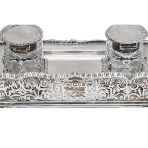 54 - AN EDWARDIAN SILVER INK STANDLONDON 1909with three quarter pierced gallery sides, raised on scrollin... 