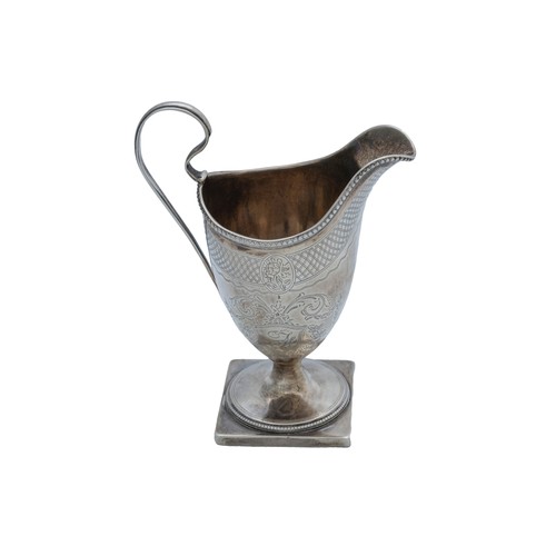 27 - A GEORGE III HELMET FORM SILVER CREAMERLONDON 1784with a 'C' scroll handle, raised on a square foot,... 