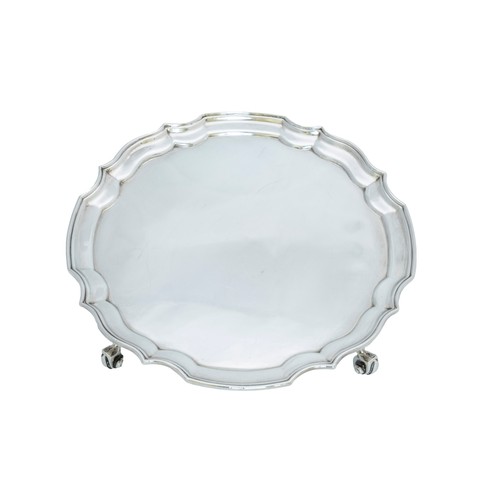 55 - A SILVER SALVERBIRMINGHAM 1966circular form with scroll edge, raised on four scroll feet20.5 cm diam... 