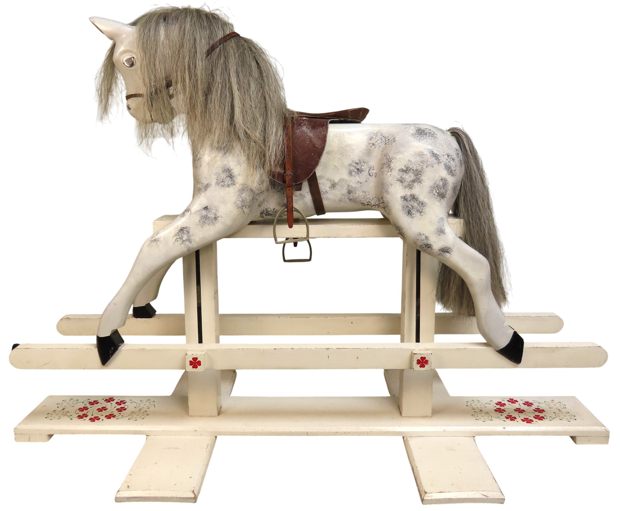 A VINTAGE DAPPLED CREAM PAINTED ROCKING HORSEraised on a trestle ...