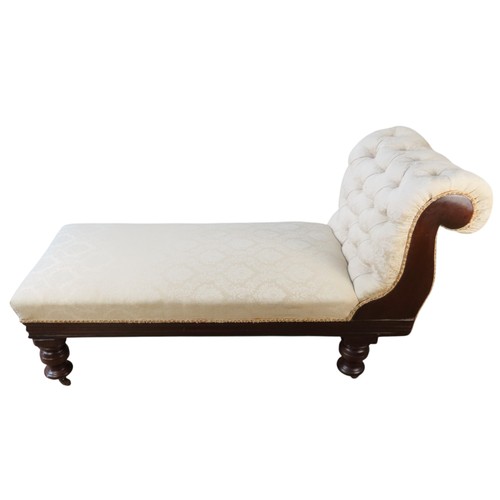 3 - A MAHOGANY CHAISE LOUNGELATE 19TH/EARLY 20TH CENTURYwith buttoned scroll arm, covered in champagne c... 