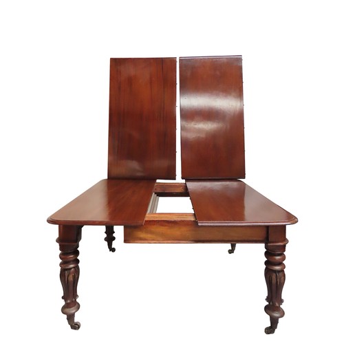 34 - A MAHOGANY DRAW-LEAF DINING TABLEMID 19TH CENTURYraised on tulip carved baluster legs, terminating i... 