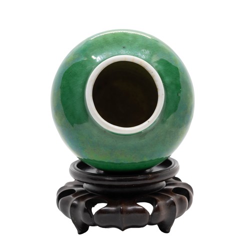 25 - A CHINESE APPLE-GREEN GLAZED JARQING DYNASTY, 18TH CENTURYwith a wood stand9.4cm highPROVENANCE: Fro... 