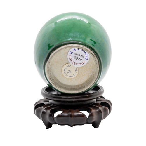 25 - A CHINESE APPLE-GREEN GLAZED JARQING DYNASTY, 18TH CENTURYwith a wood stand9.4cm highPROVENANCE: Fro... 