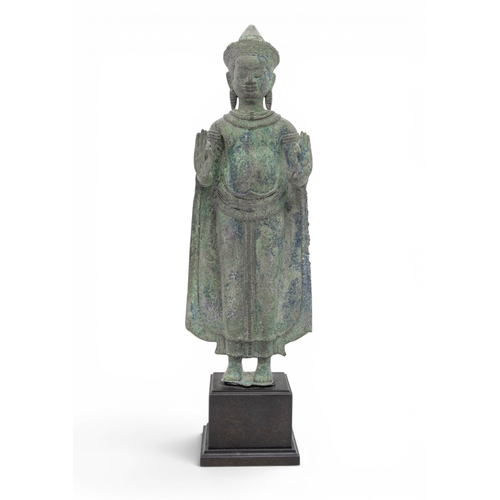 303 - A KHMER BRONZE FIGURE OF BUDDHAANGKOR PERIOD, 12TH CENTURYcast standing with hands in abhayamudra, r... 