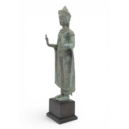 303 - A KHMER BRONZE FIGURE OF BUDDHAANGKOR PERIOD, 12TH CENTURYcast standing with hands in abhayamudra, r... 