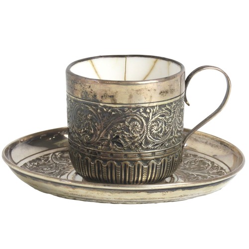18 - A LATE VICTORIAN SILVER COVERED CUP AND SAUCERLONDON 1887the porcelain lined cup and saucer with rep... 