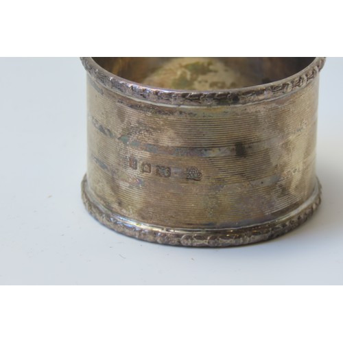 31 - A MIXED GROUP OF FOUR SILVER NAPKIN RINGSconsisting of a pair of engine turned rings and two planish... 