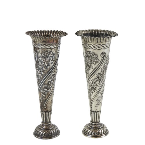 25 - A PAIR OF EDWARDIAN SILVER BUD VASESLONDON 1902with scalloped rims above repousse decorated tapering... 