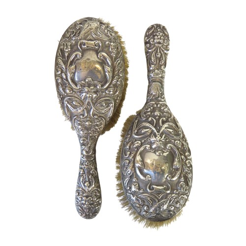 26 - A PAIR OF EDWARDIAN SILVER BACKED BRUSHESBIERMINGHAM 1907marked for W J Myatt & Co.the ornate re... 