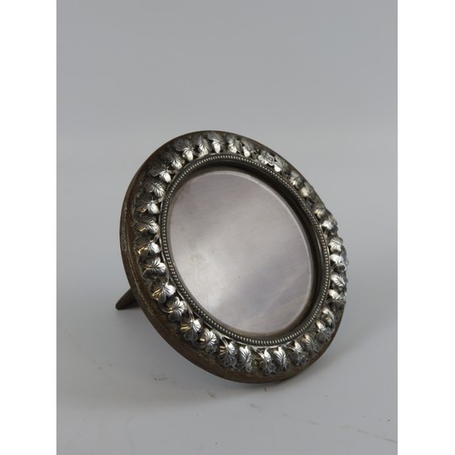 12 - A VINTAGE CIRCULAR SILVER MOUNTED PHOTOGRAPH FRAMEwith leaf decorated border (15.2 cm diam)together ... 