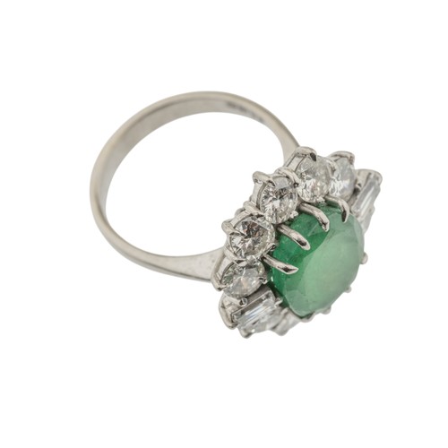 221 - AN EMERALD AND DIAMOND RING,the central oval cut emerald claw set within a surround of brilliant cut... 