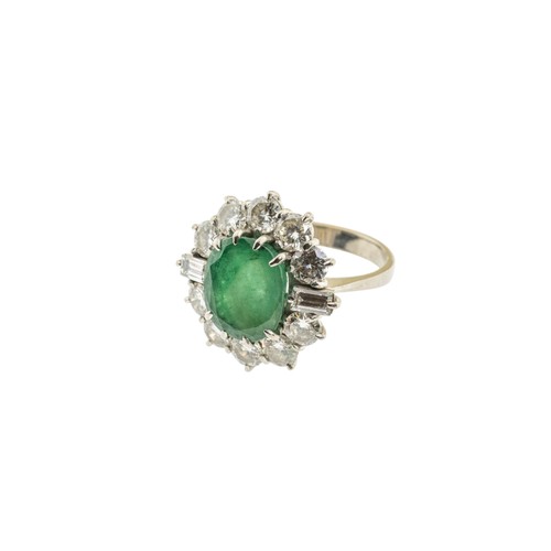 221 - AN EMERALD AND DIAMOND RING,the central oval cut emerald claw set within a surround of brilliant cut... 