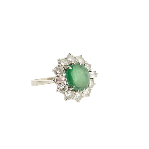 221 - AN EMERALD AND DIAMOND RING,the central oval cut emerald claw set within a surround of brilliant cut... 
