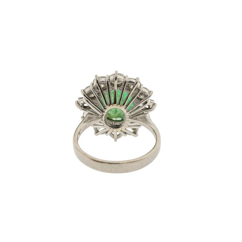 221 - AN EMERALD AND DIAMOND RING,the central oval cut emerald claw set within a surround of brilliant cut... 