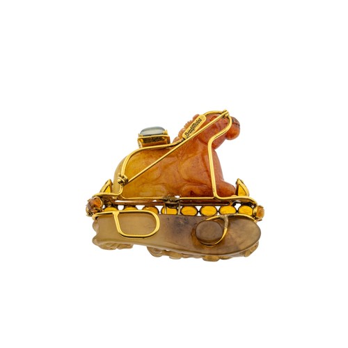 237 - A MULTI GEM SET HORSE BROOCH BY IRADJ MOINI, the orange hardstone horse seated upon a carved soapsto... 