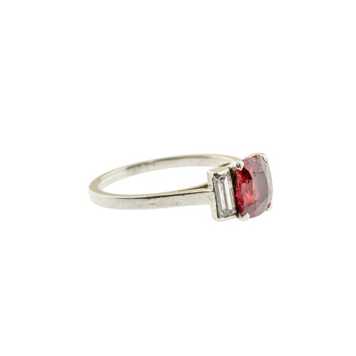 227 - A RED SPINEL AND DIAMOND RING,the oval cut red spinel in a four claw setting, between two baguette c... 