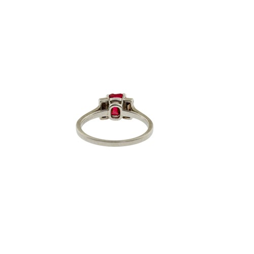 227 - A RED SPINEL AND DIAMOND RING,the oval cut red spinel in a four claw setting, between two baguette c... 