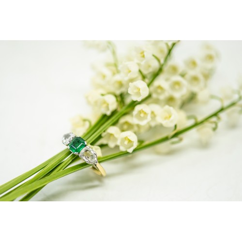 217 - AN EMERALD AND DIAMOND RING,the square shaped emerald claw set between two pear shaped diamonds.Stam... 