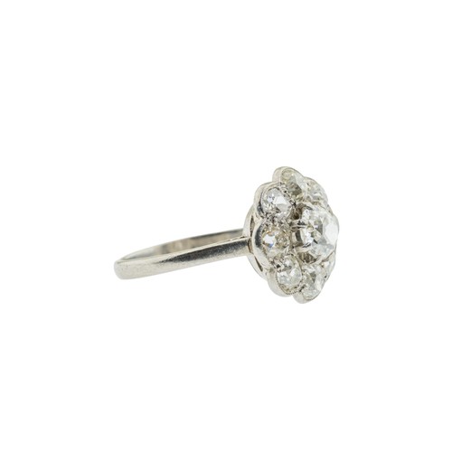 228 - A DIAMOND CLUSTER RING,the central old cut diamond, estimated to weigh 0.65 carats, claw set within ... 