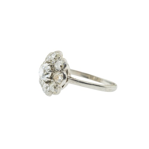 228 - A DIAMOND CLUSTER RING,the central old cut diamond, estimated to weigh 0.65 carats, claw set within ... 