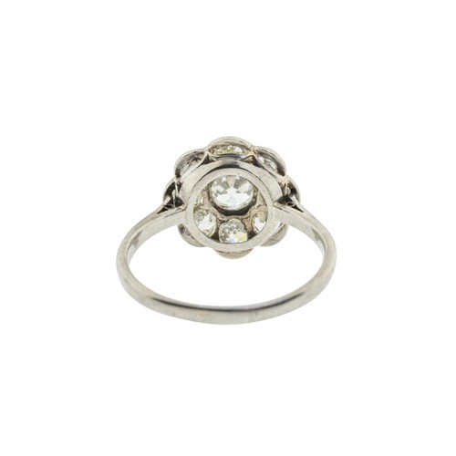 228 - A DIAMOND CLUSTER RING,the central old cut diamond, estimated to weigh 0.65 carats, claw set within ... 