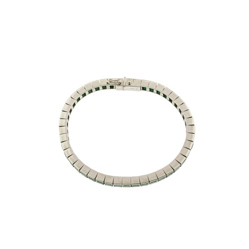 216 - AN ART DECO EMERALD BRACELET,the uniform row of step-cut emeralds in articulated settings, concealed... 