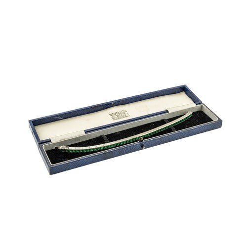 216 - AN ART DECO EMERALD BRACELET,the uniform row of step-cut emeralds in articulated settings, concealed... 