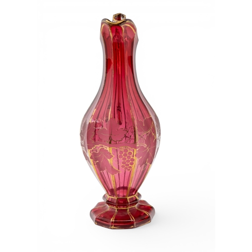 22 - A BOHEMIAN CRANBERRY GLASS EWERfaceted decagonal form, decorated with fruiting vines, with 'C' scrol... 