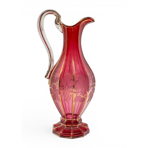 22 - A BOHEMIAN CRANBERRY GLASS EWERfaceted decagonal form, decorated with fruiting vines, with 'C' scrol... 