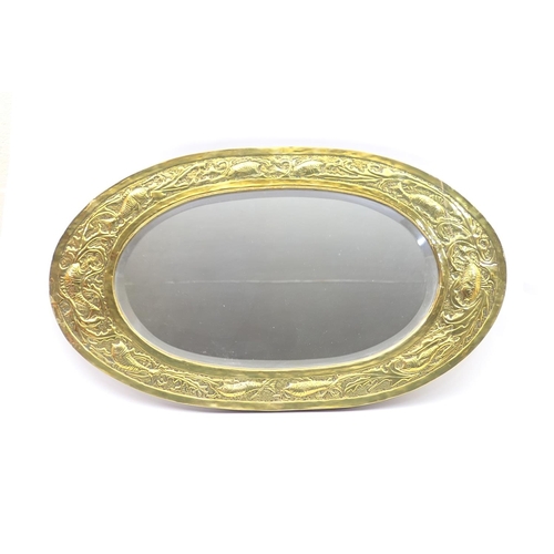 466 - Newlyn style hammered brass framed oval wall mirror, circa 1900-10, worked with fishes swimming amid... 