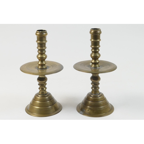 467 - Pair of Dutch bell metal candlesticks, 18th Century, multi-knopped stems with wide drip pan, over a ... 