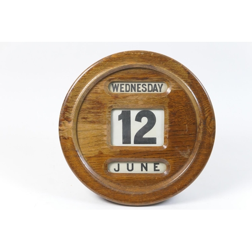 509 - George V oak circular wall calendar, with revolving printed cloth day and date, 31cm diameter