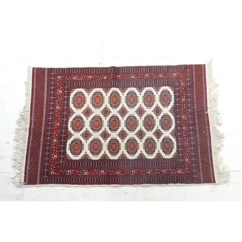 526 - Pakistani woollen rug, Bokhara style, fawn field with three rows of botehs within a madder border, 1... 