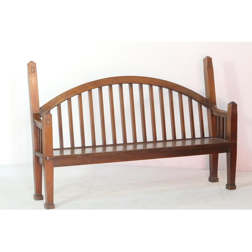 530 - Unusual Lutyens style mahogany settle, with an arched stick back with chamfered square section uprig... 