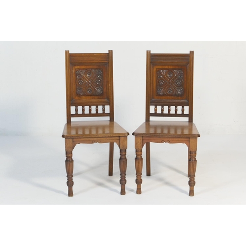 546 - Pair of Victorian walnut hall chairs, circa 1885, with channel moulded outline back enclosing a pane... 