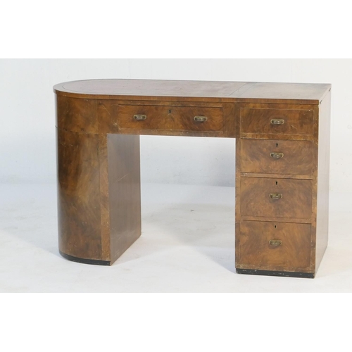 547 - Art Deco walnut kneehole desk, asymmetrical form with a curved end with two cupboard doors opening t... 