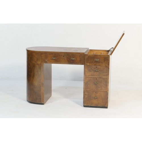 547 - Art Deco walnut kneehole desk, asymmetrical form with a curved end with two cupboard doors opening t... 