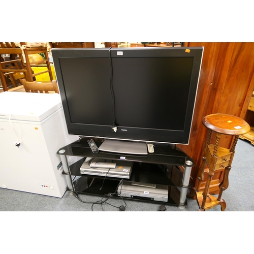 672 - Toshiba colour television on plate glass stand with Toshiba DVD player and LG DVD player