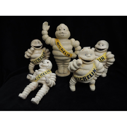 318 - Five cast iron Michelin men, one man height 21cm on base, three further men height 14cm and a tyre r... 