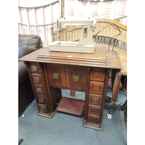 868 - Vintage walnut sewing machine table with a later Singer sewing machine